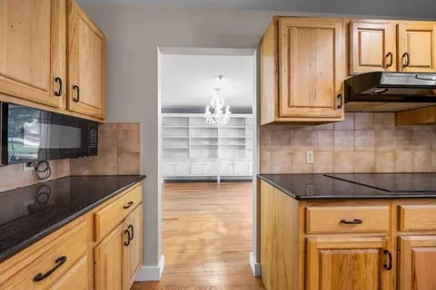 a kitchen with granite countertop white cabinets and stainless steel appliances