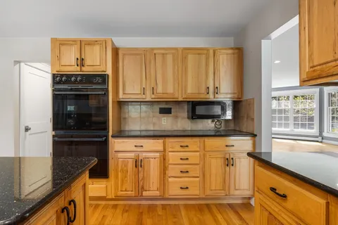 a kitchen with stainless steel appliances granite countertop a refrigerator a sink and a stove