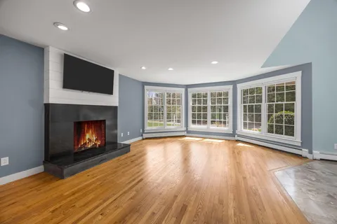 a view of an empty room with a window and a fireplace