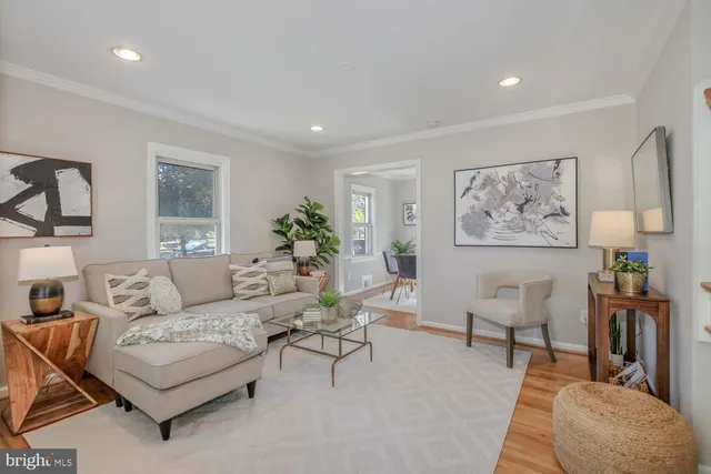 a living room with furniture and paintings on the wall
