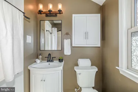 a bathroom with a toilet sink and mirror