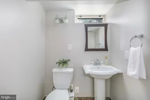 a bathroom with a toilet sink and mirror