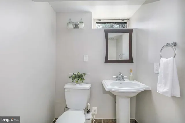 a bathroom with a toilet sink and mirror