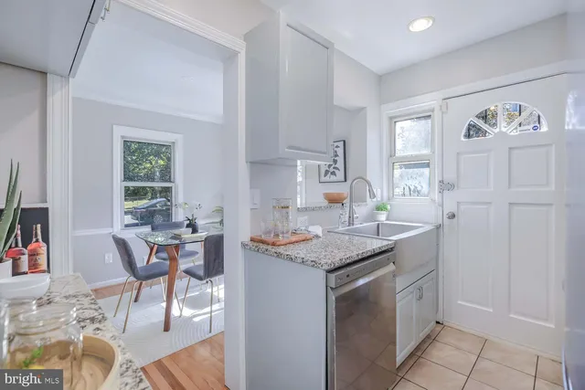 a dining hall with stainless steel appliances granite countertop a stove a sink a dining table and chairs