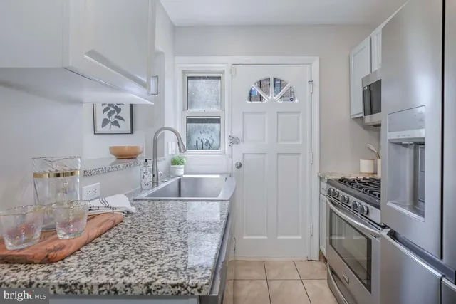 a kitchen with stainless steel appliances granite countertop a refrigerator and a stove