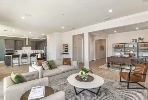 a living room with furniture kitchen view and a table