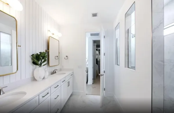 a bathroom with a double vanity sink mirror and shower