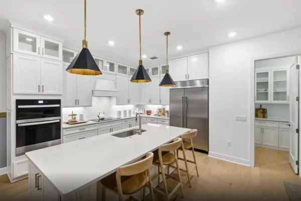 a kitchen with stainless steel appliances kitchen island granite countertop a sink a stove and chairs