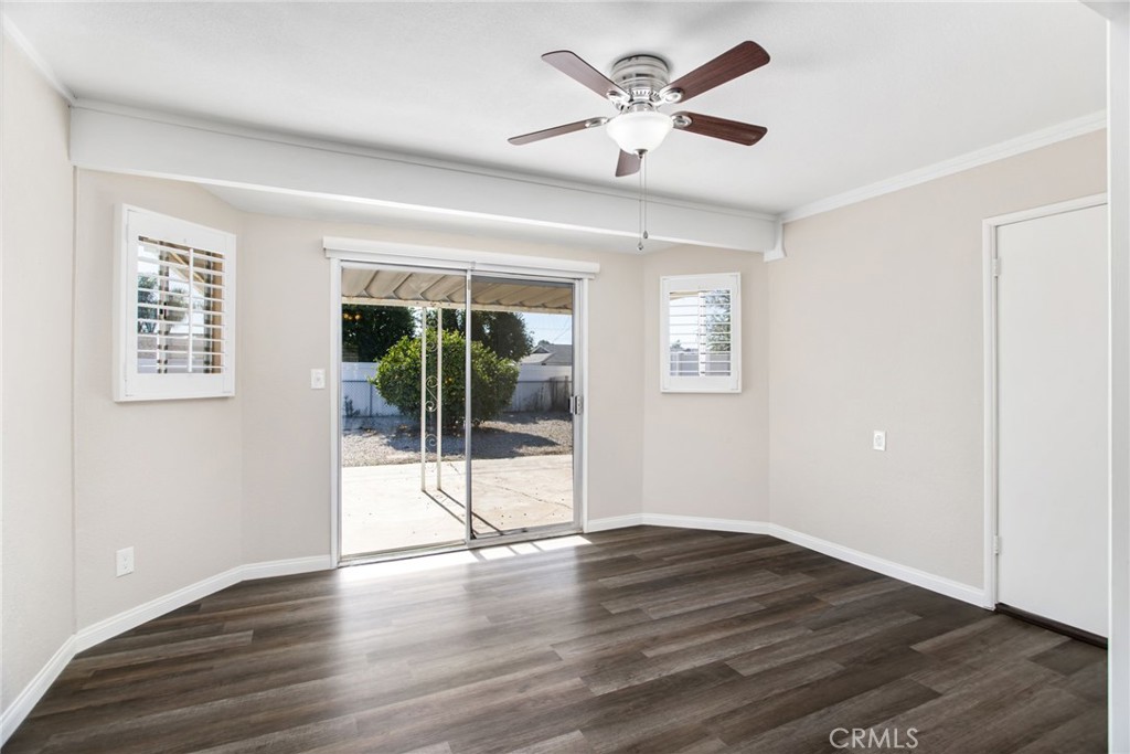 27161 Pinehurst Road Menifee, CA 92586 - Photo 11 of 35 a view of an empty room with wooden floor and a ceiling fan