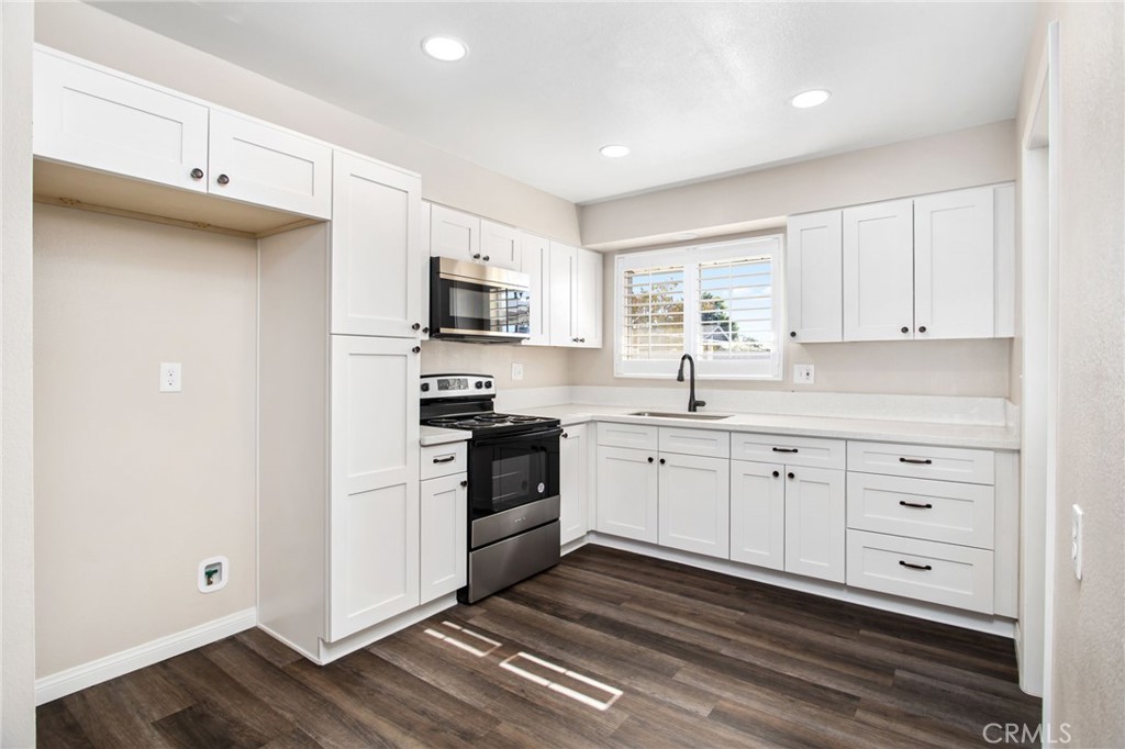 27161 Pinehurst Road Menifee, CA 92586 - Photo 13 of 35 a kitchen with cabinets stainless steel appliances a sink and a window