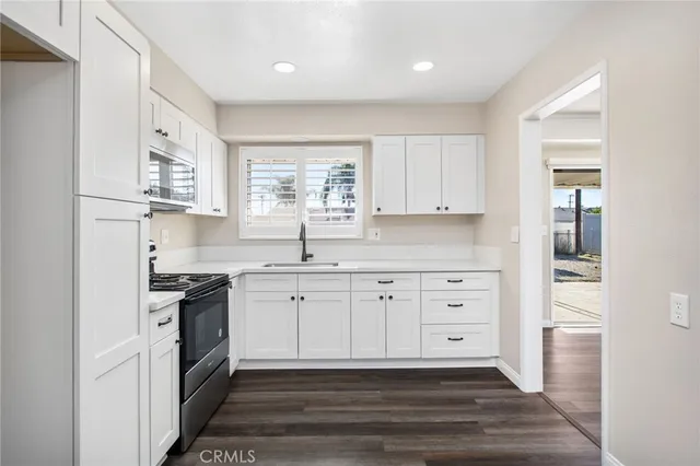 a kitchen with stainless steel appliances granite countertop a sink and a stove