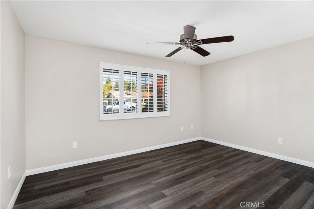 27161 Pinehurst Road Menifee, CA 92586 - Photo 19 of 35 a view of an empty room with wooden floor and a window