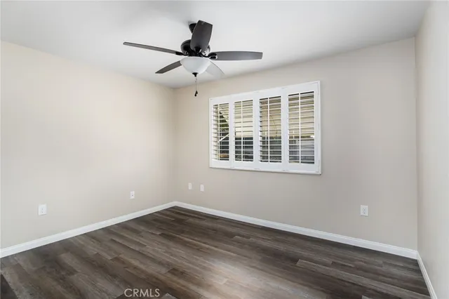 a view of a big room with wooden floor and windows