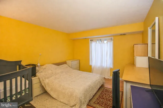 a view of a bedroom with wooden floor and windows