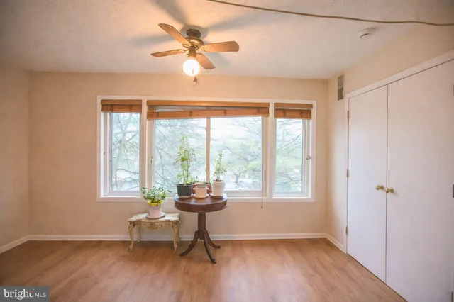a view of an empty room with a window and wooden floor