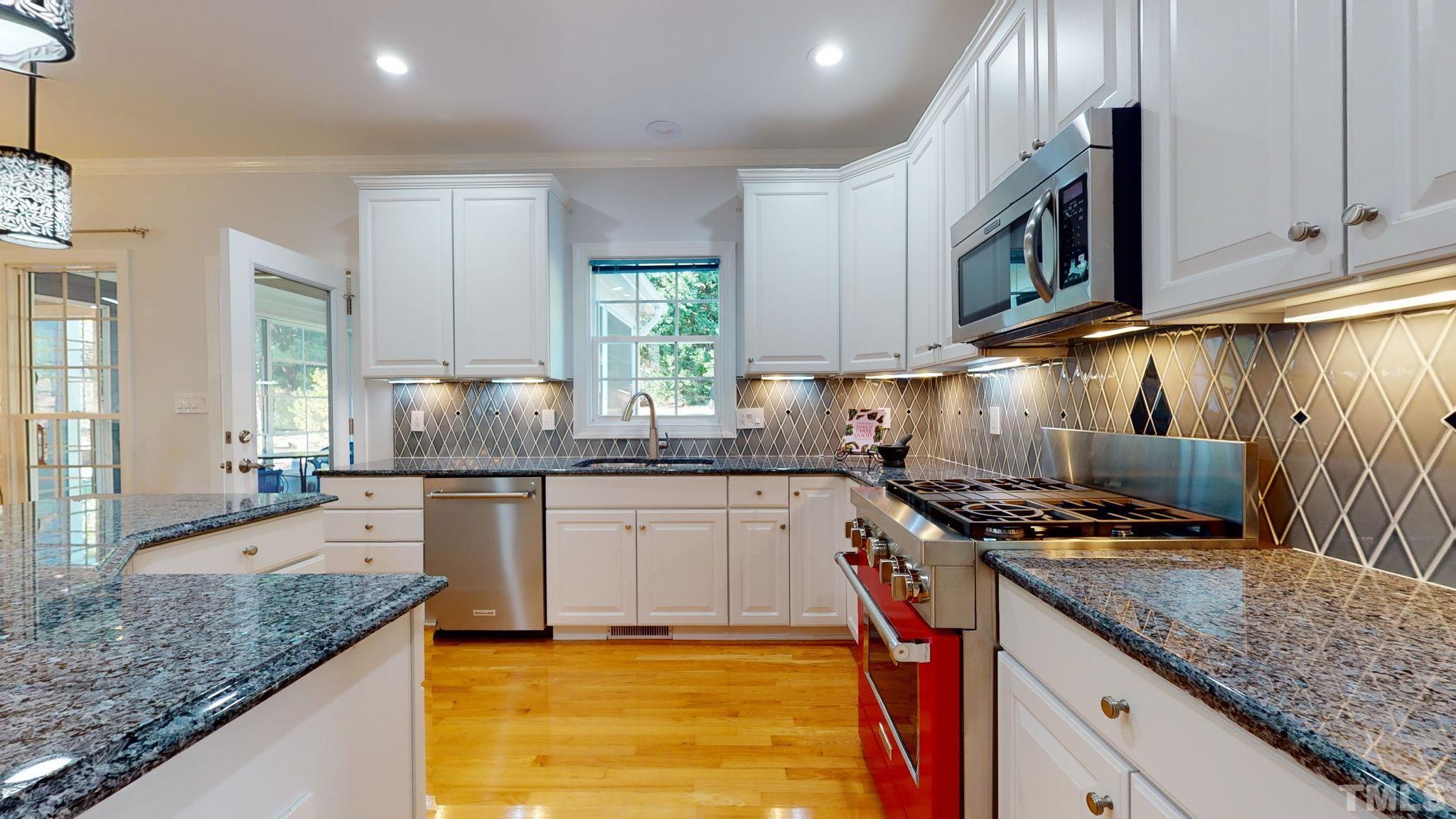 1512 Wood Spring Court Raleigh, NC 27614 - Photo 17 of 39 a kitchen with granite countertop stainless steel appliances a sink stove and cabinets
