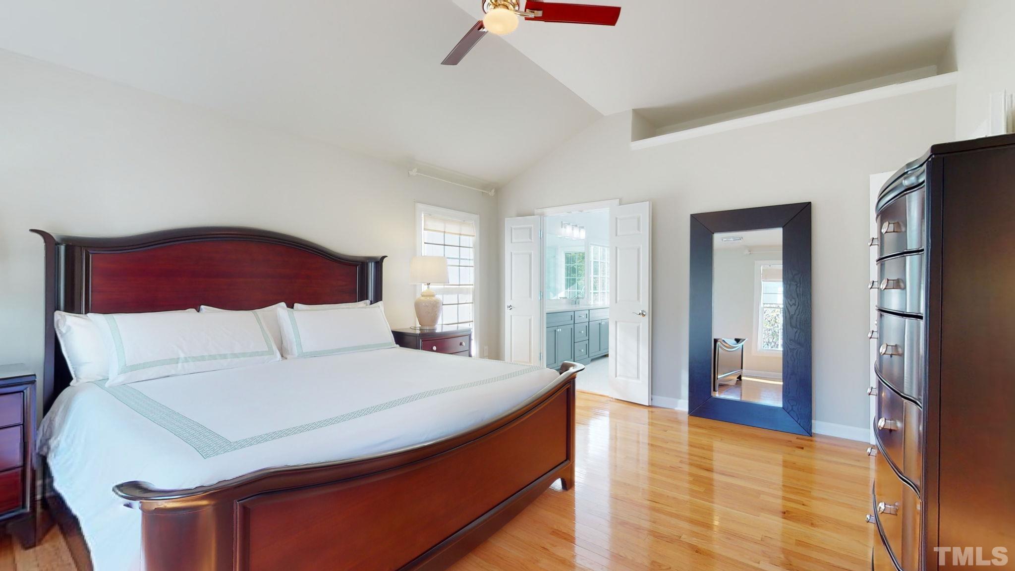 1512 Wood Spring Court Raleigh, NC 27614 - Photo 21 of 39 a bedroom with a large bed and a chandelier