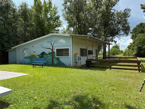 a front view of house with yard and trees in the background