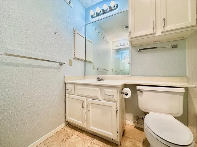 a spacious bedroom with a bed and a chandelier