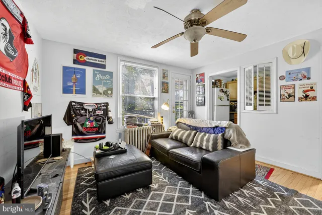 a living room with furniture ceiling fan and a window