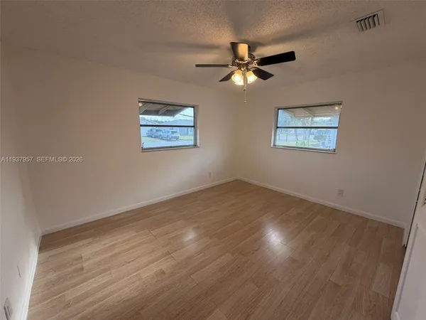 a view of empty room with wooden floor