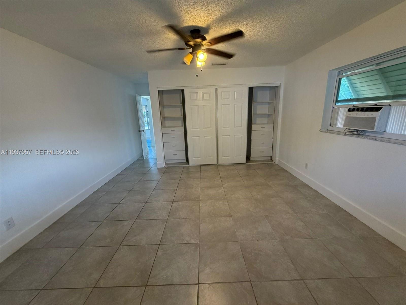 9507 Northwest 80th Court Tamarac, FL 33321 - Photo 13 of 22 a view of an empty room with a ceiling fan and window