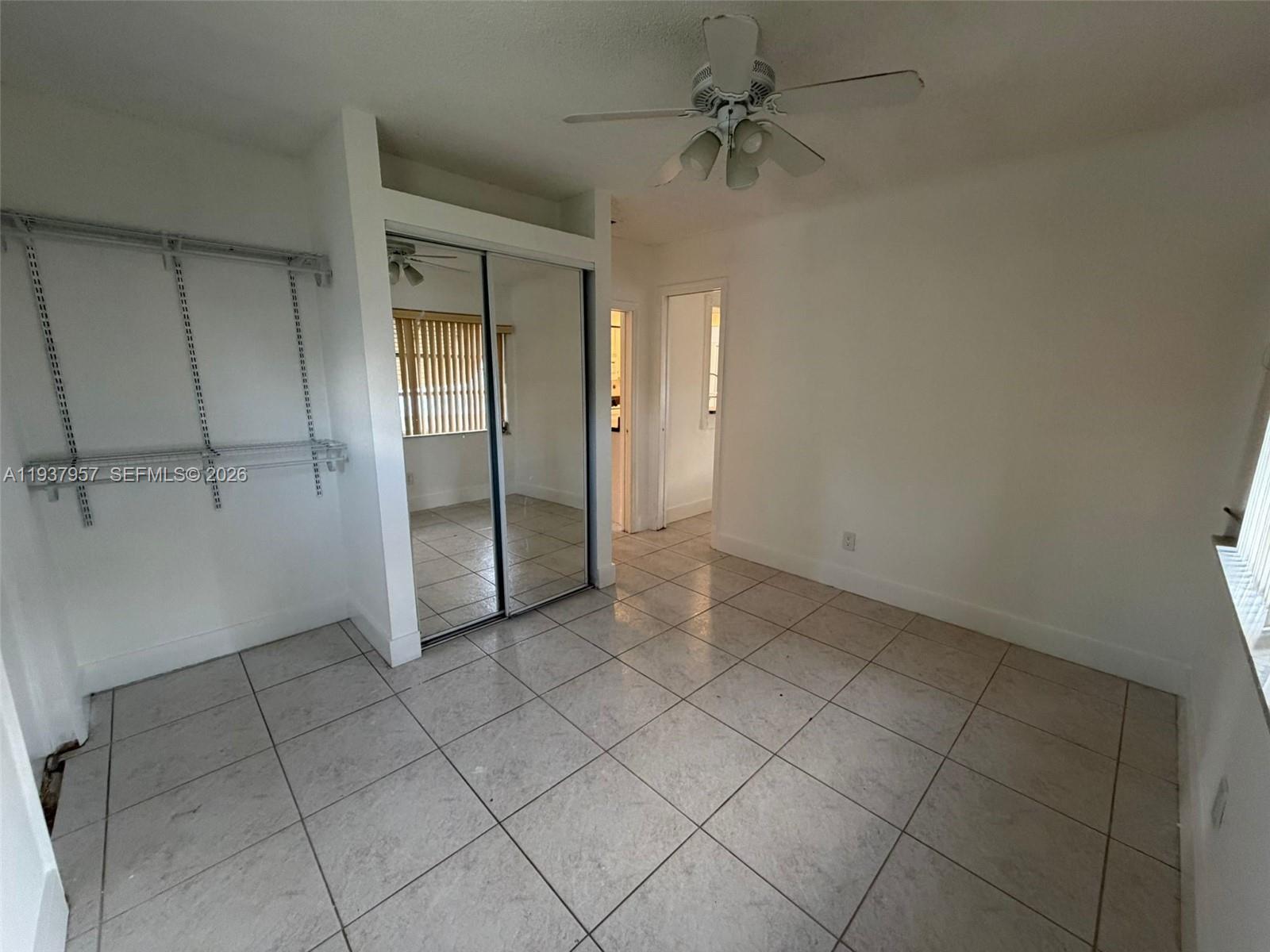 9507 Northwest 80th Court Tamarac, FL 33321 - Photo 16 of 22 an empty room with a ceiling fan and glass door shower