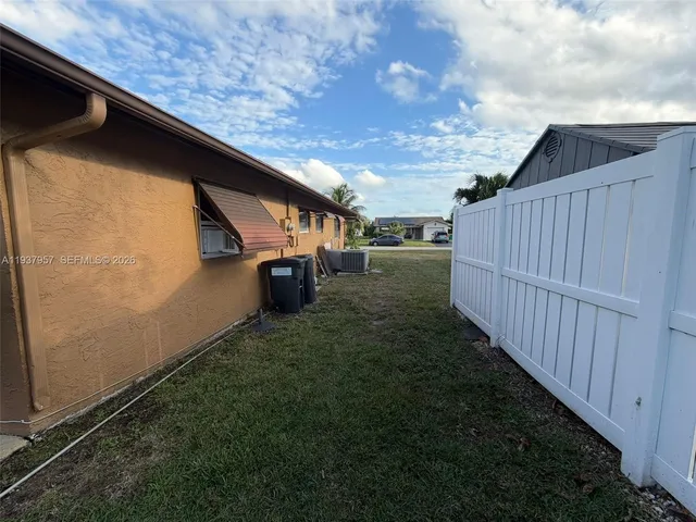 a backyard of a house with table and chairs