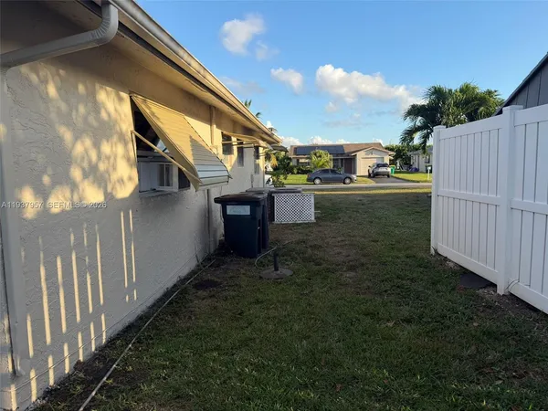 a backyard of a house with table and chairs