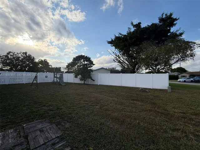 a view of a patio with a table chairs and a backyard