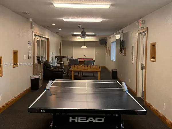 a room with pool table and windows