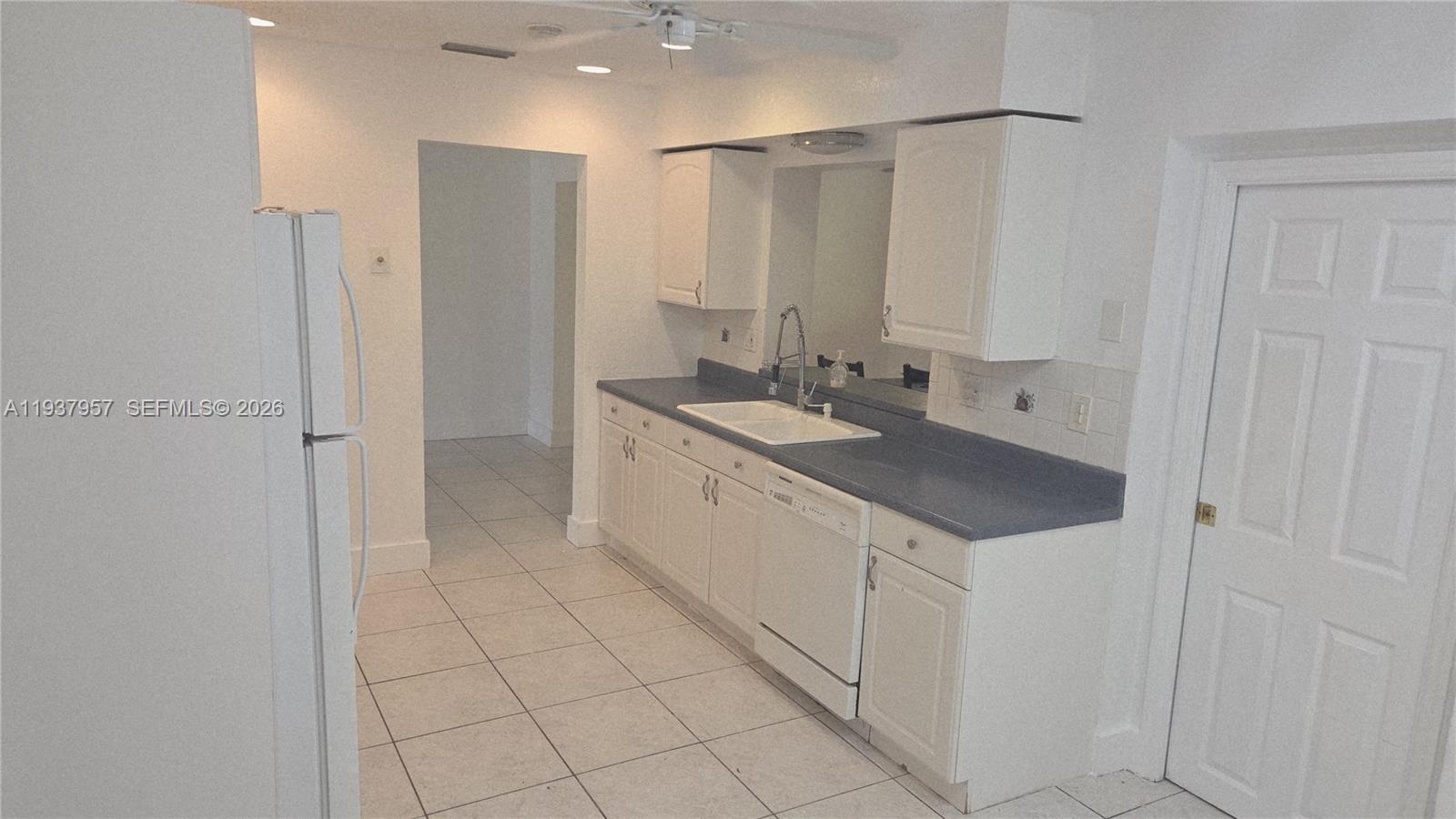 9507 Northwest 80th Court Tamarac, FL 33321 - Photo 4 of 22 a bathroom with a granite countertop sink a mirror and a shower