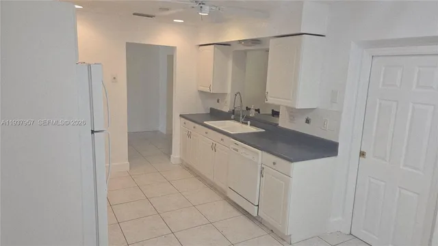 a bathroom with a granite countertop sink a mirror and a shower