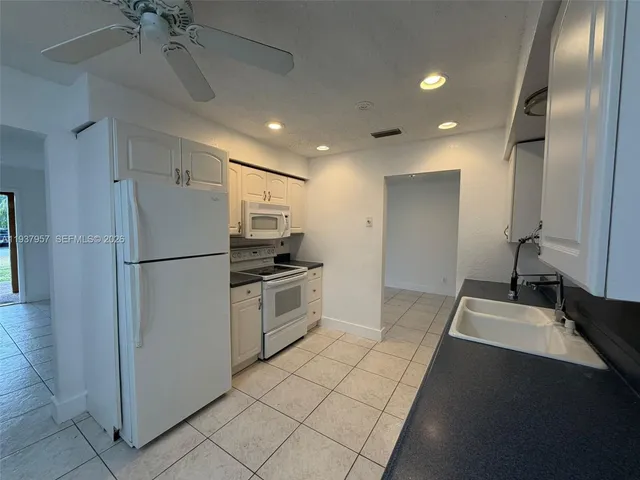 a kitchen with a refrigerator and a sink