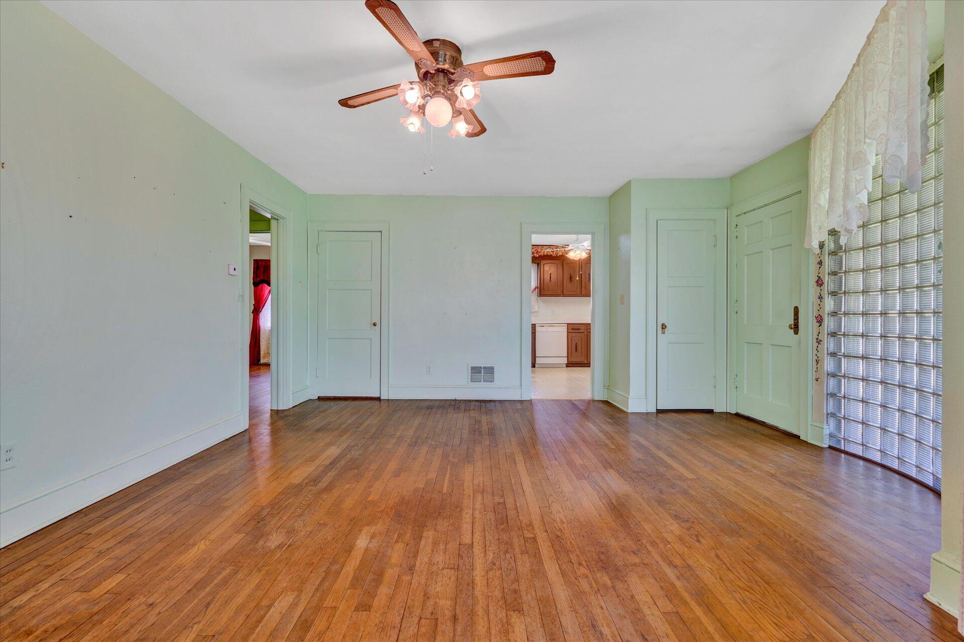5120 Starkey Road Roanoke, VA 24018 - Photo 5 of 17 an empty room with wooden floor and ceiling fan
