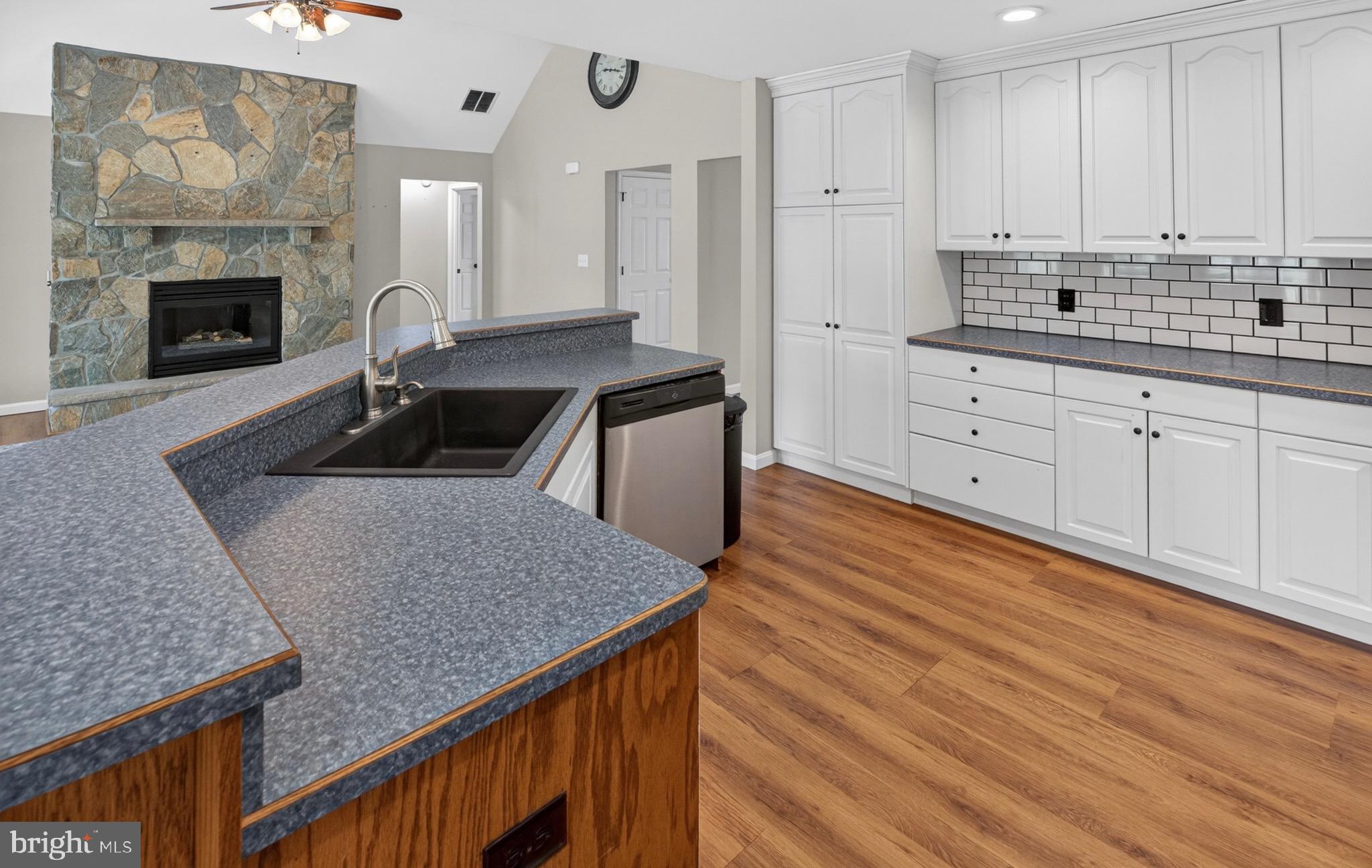 18315 Atlanta Road Bridgeville, DE 19933 - Photo 9 of 28 a kitchen with stainless steel appliances granite countertop a sink dishwasher and white cabinets with wooden floor