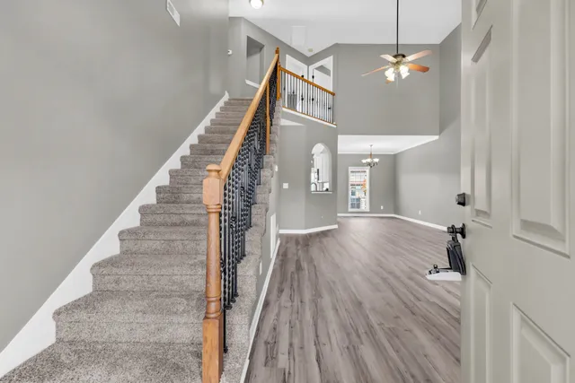 a view of a hallway with wooden floor and staircase