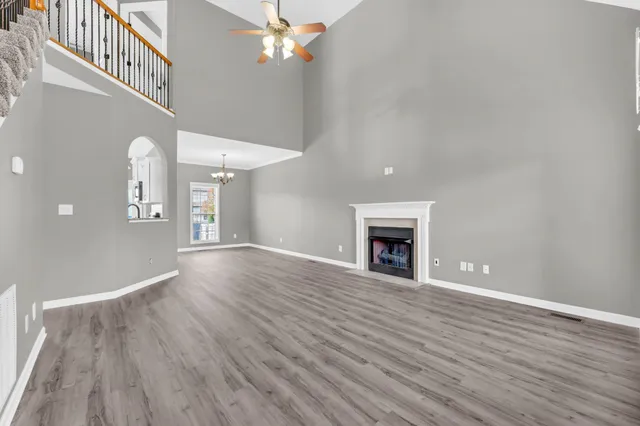 wooden floor fireplace and windows in an empty room