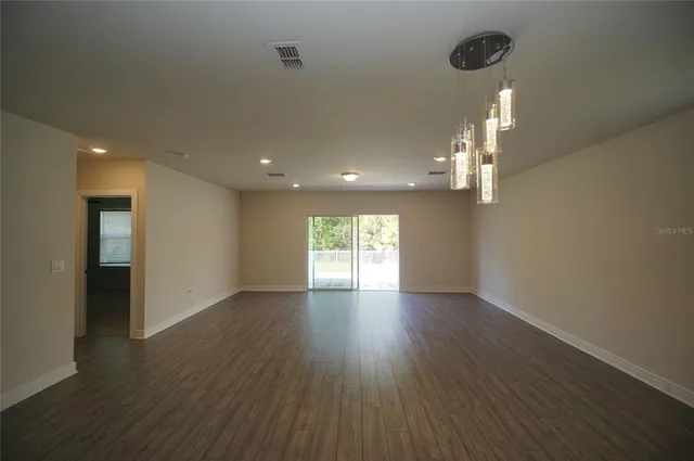 a large white kitchen with a large counter top a sink stainless steel appliances and cabinets