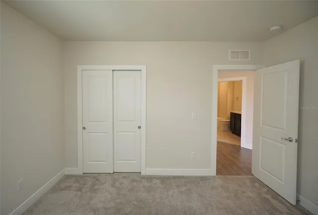 an empty room and chandelier fan