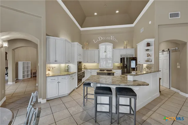 a large white kitchen with a sink and cabinets