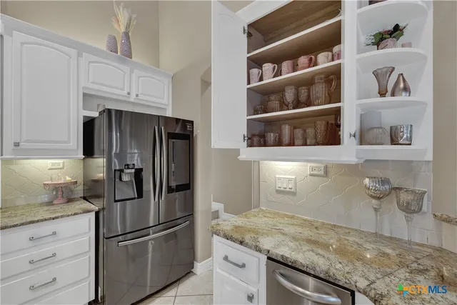 a kitchen with stainless steel appliances granite countertop a refrigerator and a stove