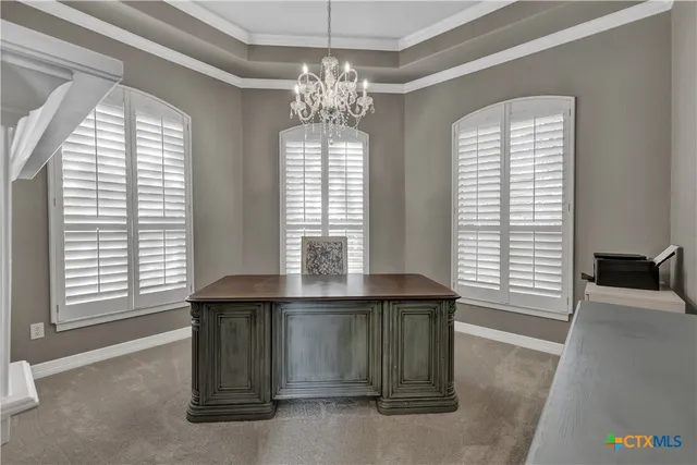a view of a room with a large window and chandelier