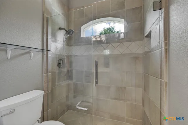 a bathroom with a toilet and a shower