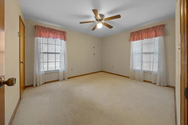 an aerial view of a house with swimming pool a yard and a large tree