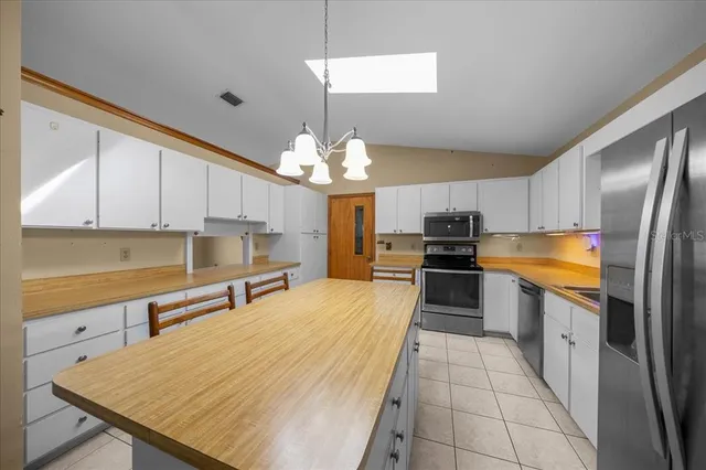 a kitchen that has a lot of cabinets in it and appliances