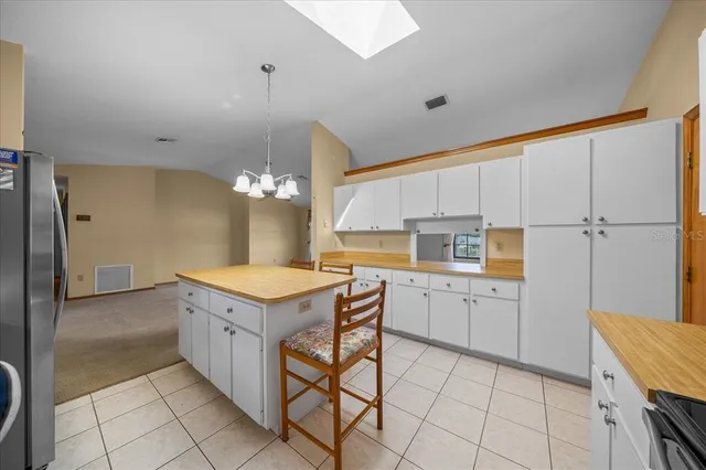 a kitchen with a dining table chairs and white cabinets