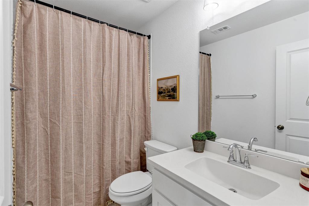136 Derrett Lane Rhome, TX 76078 - Photo 29 of 40 a bathroom with a sink a toilet and shower curtain
