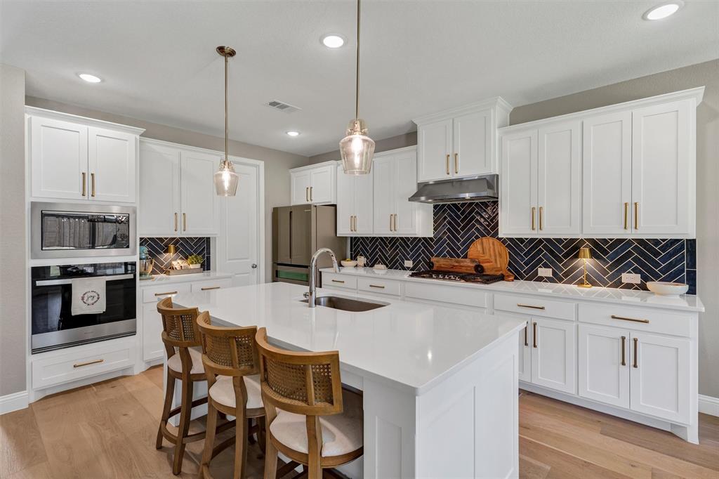 136 Derrett Lane Rhome, TX 76078 - Photo 5 of 40 a kitchen with white cabinets stainless steel appliances and chairs