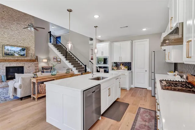 a kitchen with a dining table chairs sink and stove top oven